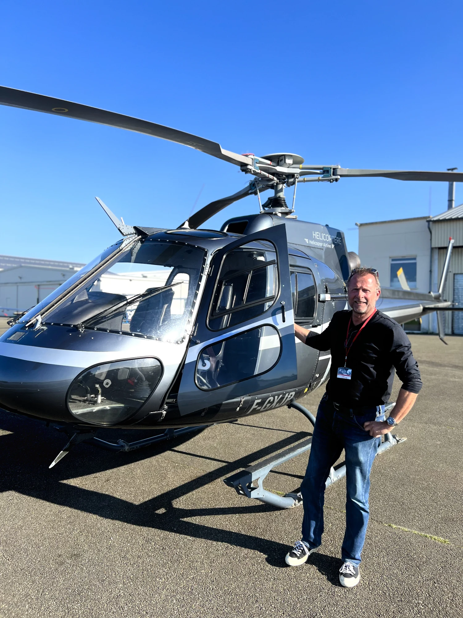 Nicolas devant un hélicoptère sur le tarmac